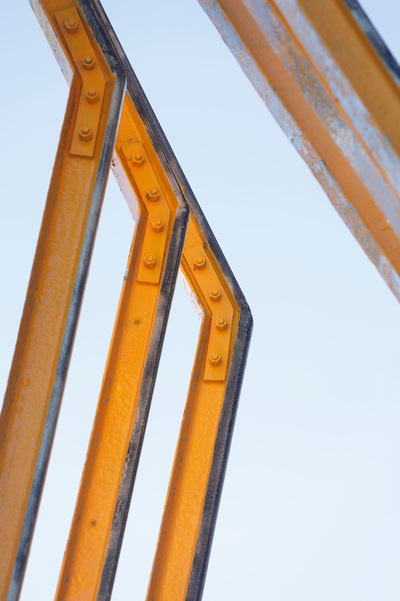 Close up image of the yellow painted railway steel components of 'The Rail' Artwork by VOXLAB